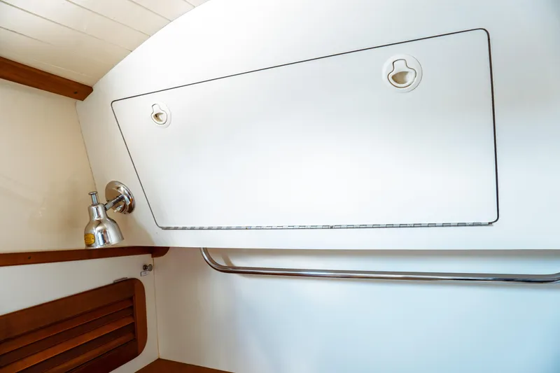 Slide: The Image of Interior of 2000 Hinckley Picnic Boat Classic, featuring sleek white paneling and chrome fixtures. - 56