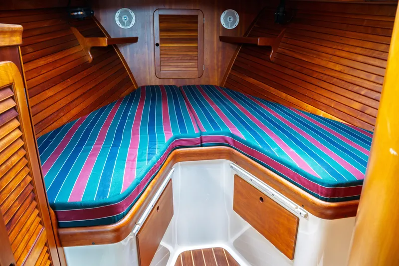 Slide: The Image of 2000 Hinckley Picnic Boat Classic interior with striped cushions and wooden paneling. - 58