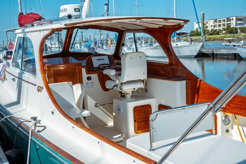 Slide: The Image of 2000 Hinckley Picnic Boat Classic at marina, featuring elegant wood and white interior. - 6