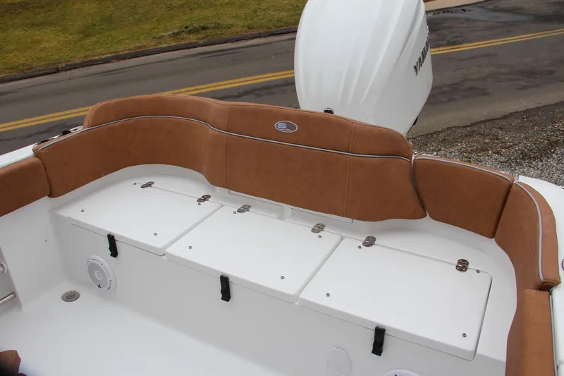 Slide: The Image of 2024 Sea Hunt Ultra 234 boat with cushioned seating and storage compartments. - 10