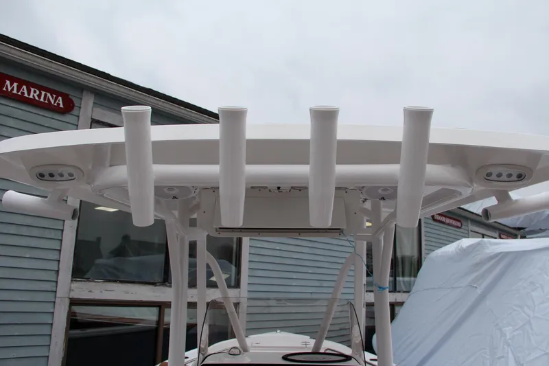 Slide: The Image of 2024 Sea Hunt Ultra 234 boat with rod holders and T-top at marina. - 18