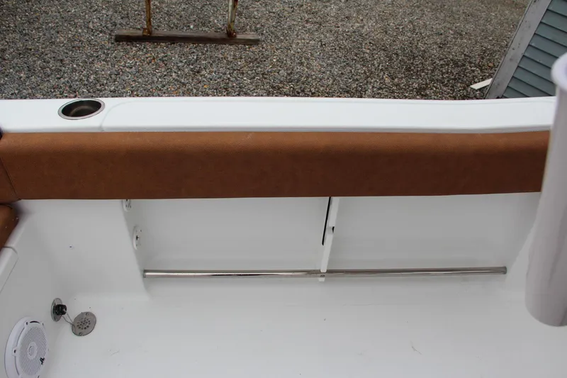 Slide: The Image of 2024 Sea Hunt Ultra 234 boat interior with brown cushioned seating and white deck. - 19