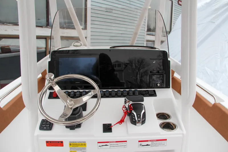 Slide: The Image of 2024 Sea Hunt Ultra 234 boat console with steering wheel and controls. - 24