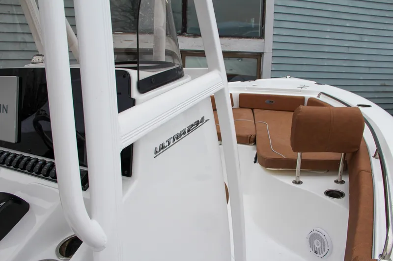 Slide: The Image of 2024 Sea Hunt Ultra 234 boat interior with brown seating and white console. - 30