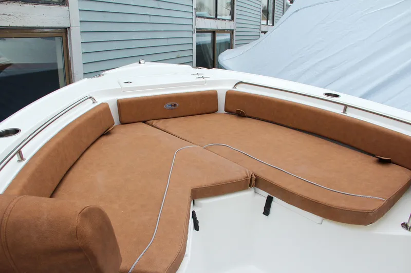 Slide: The Image of 2024 Sea Hunt Ultra 234 boat with brown cushioned seating area. - 31