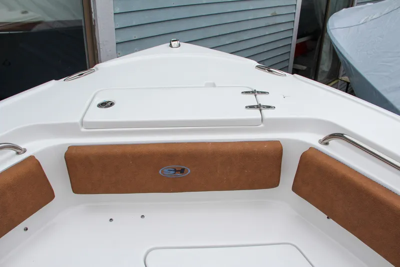 Slide: The Image of 2024 Sea Hunt Ultra 234 boat bow with cushioned seating and storage compartment. - 36