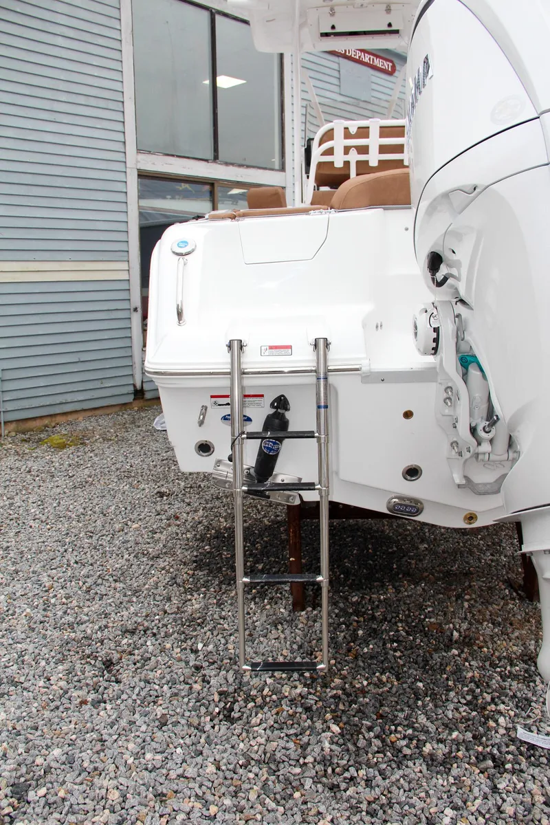 Slide: The Image of 2024 Sea Hunt Ultra 234 boat with rear ladder and outboard motor. - 9