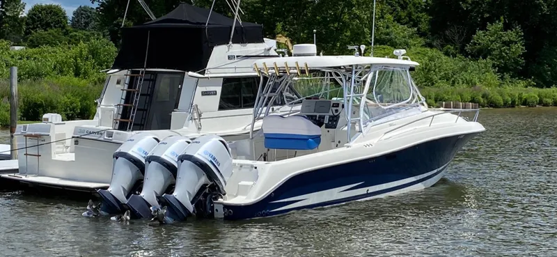 Slide: The Image of 2005 Hydra-Sports Vector 3300 VX boat with triple outboard motors docked on a calm river. - 10