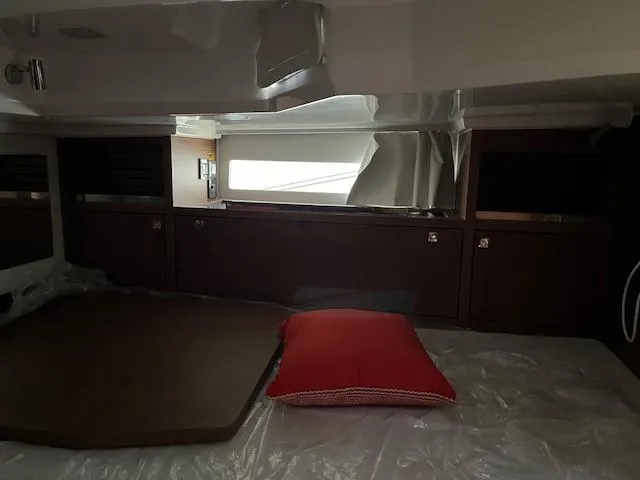 Slide: The Image of Interior cabin of 2024 Jeanneau Leader 12.5 WA with red pillow. - 12
