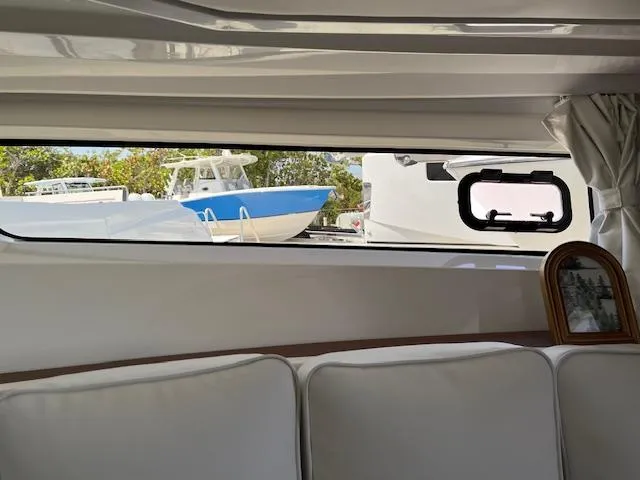Slide: The Image of Interior view of 2024 Jeanneau Leader 12.5 WA yacht with window showing boats outside. - 13