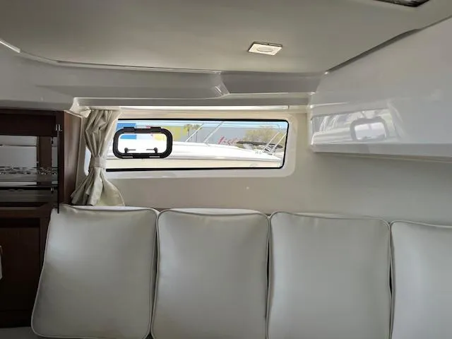 Slide: The Image of Interior cabin of 2024 Jeanneau Leader 12.5 WA with white seating and window. - 14