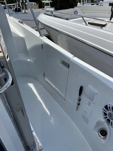 Slide: The Image of 2024 Jeanneau Leader 12.5 WA boat deck with white interior and stainless steel fixtures. - 18