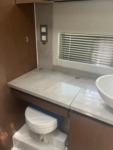 Slide: The Image of 2024 Jeanneau Leader 12.5 WA bathroom with modern fixtures and wooden cabinetry. - 7