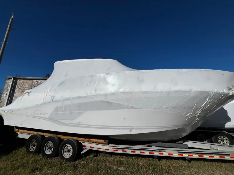 Slide: The Image of 2024 Jeanneau Leader 10.5 WA Series 2 boat covered on a trailer. - 0