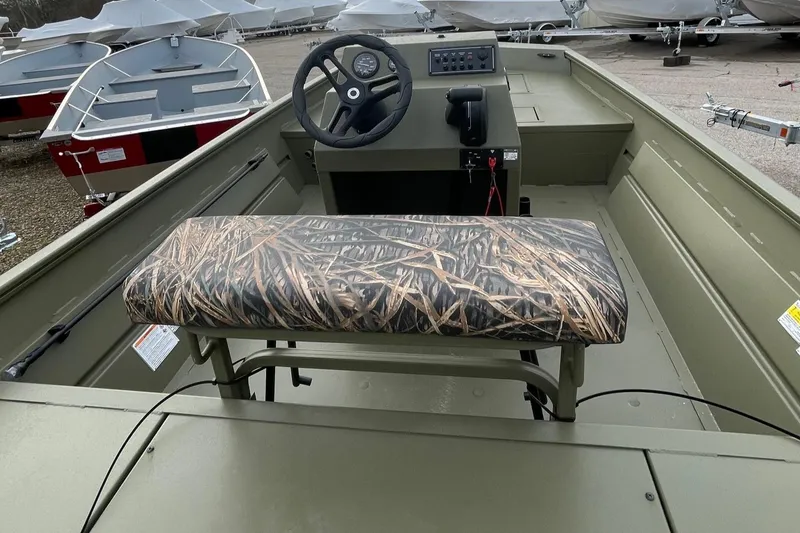 Slide: The Image of 2024 Lund 1870 Predator boat interior with camo bench seat and steering console. - 3