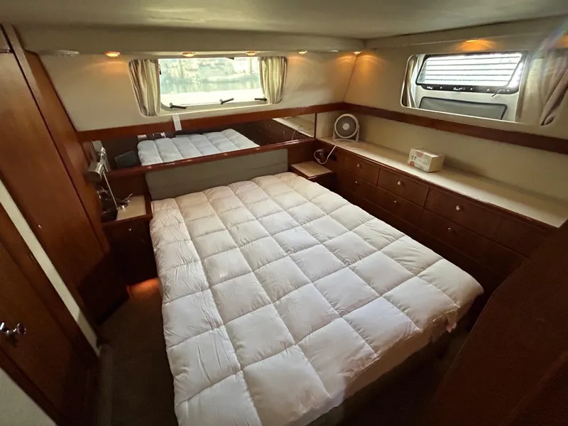 Slide: The Image of Luxurious bedroom in 1994 Bayliner 4587 Motoryacht with cozy bedding and wooden cabinetry. - 13