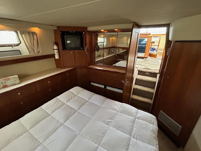 Slide: The Image of Luxurious bedroom interior of 1994 Bayliner 4587 Motoryacht with wood cabinetry and cozy bedding. - 14