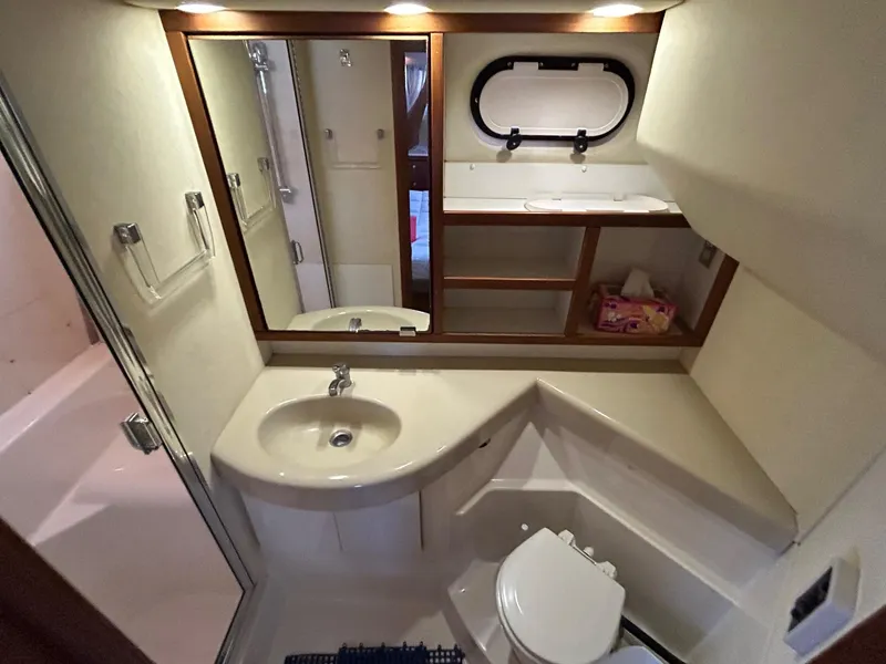 Slide: The Image of 1994 Bayliner 4587 Motoryacht bathroom with sink, toilet, mirror, and storage shelves. - 15