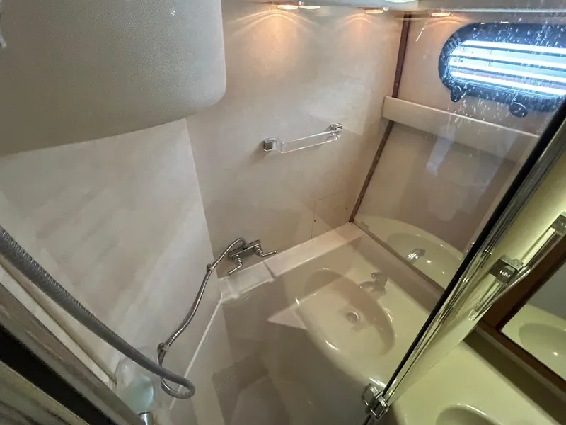 Slide: The Image of 1994 Bayliner 4587 Motoryacht bathroom with shower, sink, and porthole window. - 16