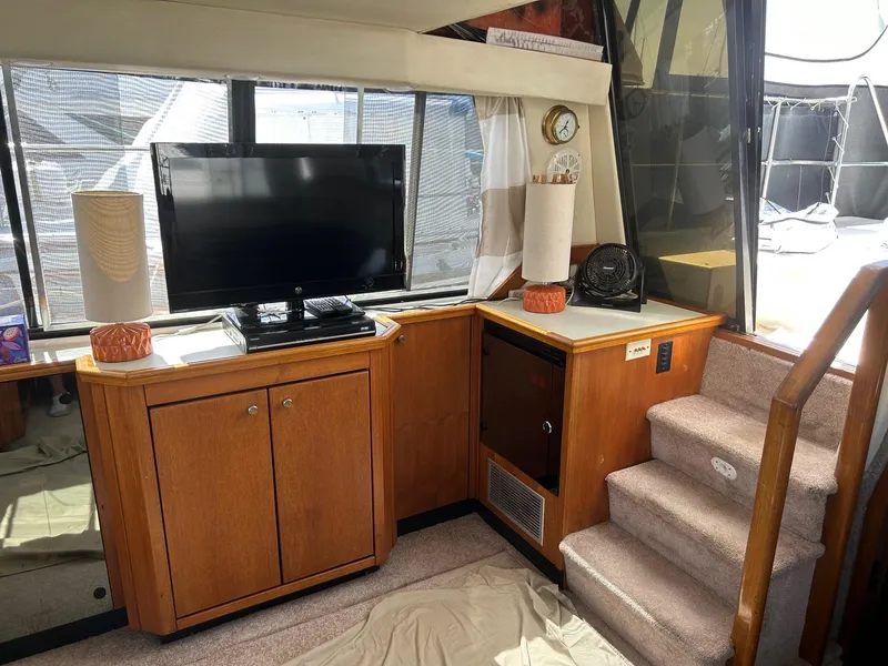 Slide: The Image of Interior of 1994 Bayliner 4587 Motoryacht with TV, wooden cabinets, and carpeted stairs. - 6