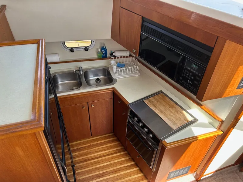 Slide: The Image of 1994 Bayliner 4587 Motoryacht kitchen with dual sinks, stove, and microwave. - 8