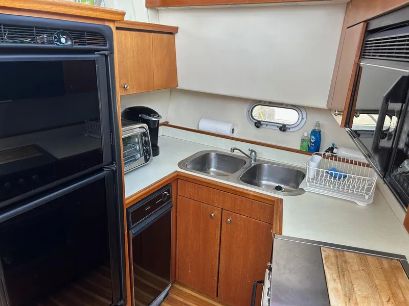 Slide: The Image of 1994 Bayliner 4587 Motoryacht kitchen with dual sinks, appliances, and wood cabinetry. - 9