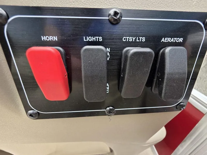 Slide: The Image of Control panel of 2025 Sun Tracker BASS BUGGY® 18 DLX with switches for horn, lights, and aerator. - 11