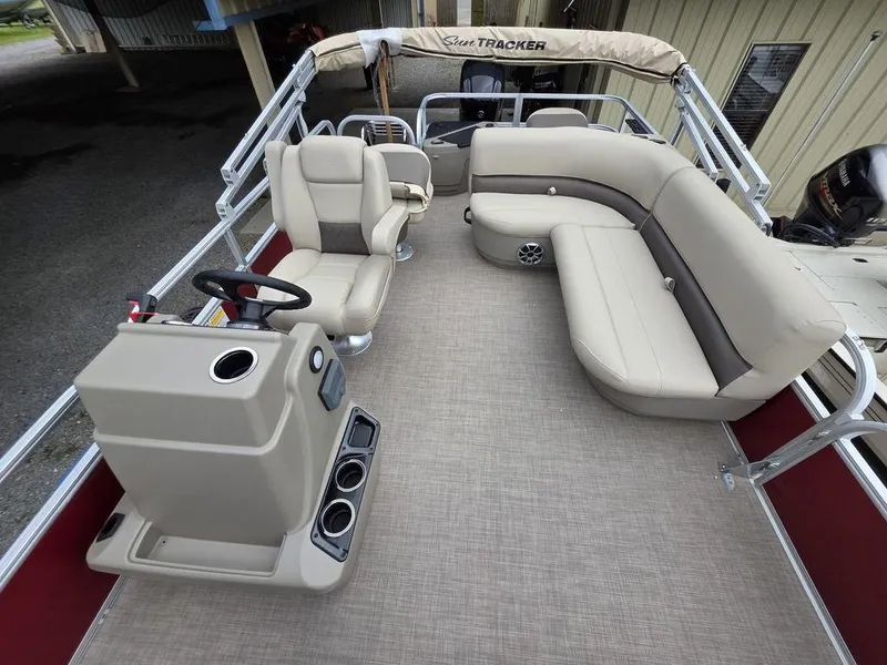 Slide: The Image of 2025 Sun Tracker BASS BUGGY® 18 DLX pontoon boat interior with beige seating and steering console. - 20