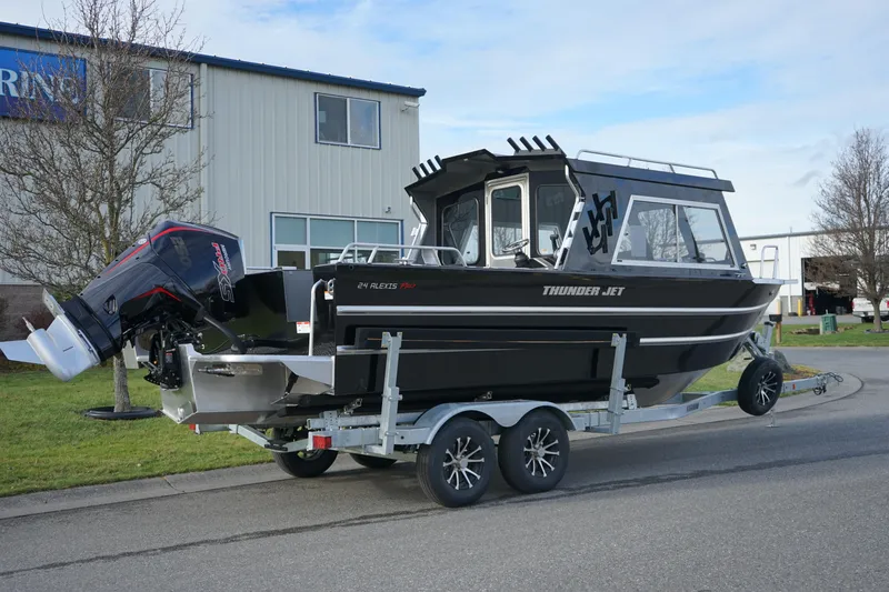 Slide: The Image of 2024 Thunder Jet 24 Alexis Pro HT boat on a trailer outside a building. - 3