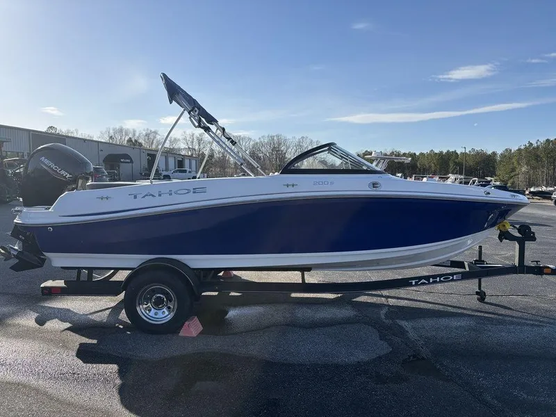 Slide: The Image of 2024 Tahoe 200 S boat on trailer, blue and white design, parked outdoors. - 4
