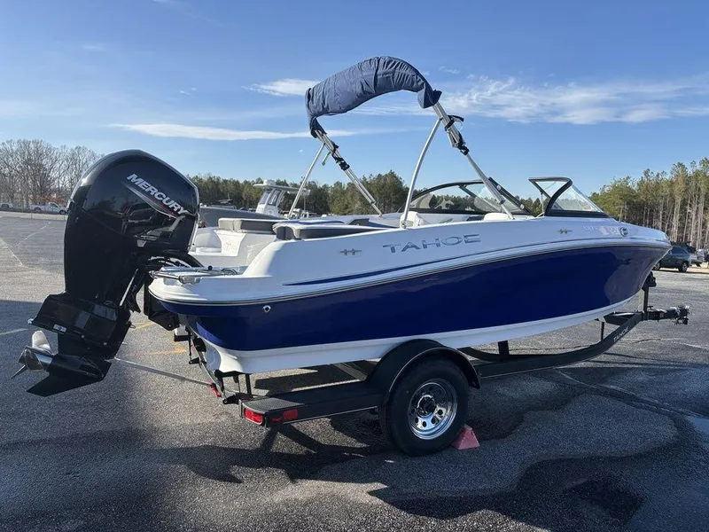 Slide: The Image of 2024 Tahoe 200 S boat with Mercury outboard motor on trailer, parked outdoors. - 6