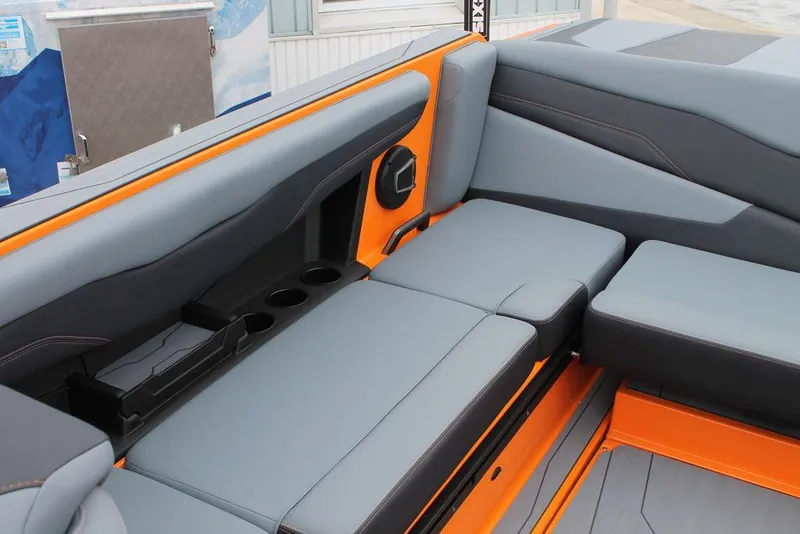 Slide: The Image of 2024 Axis T235 boat interior with gray and orange seating, cup holders, and speaker. - 11