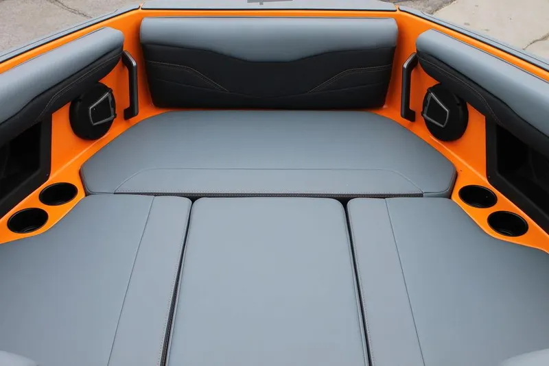 Slide: The Image of 2024 Axis T235 boat interior with gray and orange seating, cup holders, and speakers. - 6