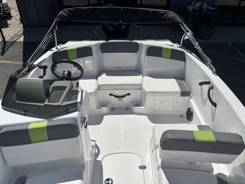 Slide: The Image of 2024 Tahoe T16 boat interior with gray and green seating, steering wheel, and storage compartments. - 13