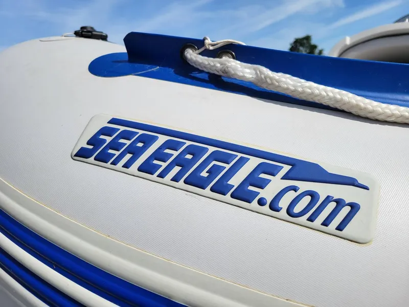 Slide: The Image of Sea Eagle inflatable boat with logo, featuring blue accents and rope handle. - 8