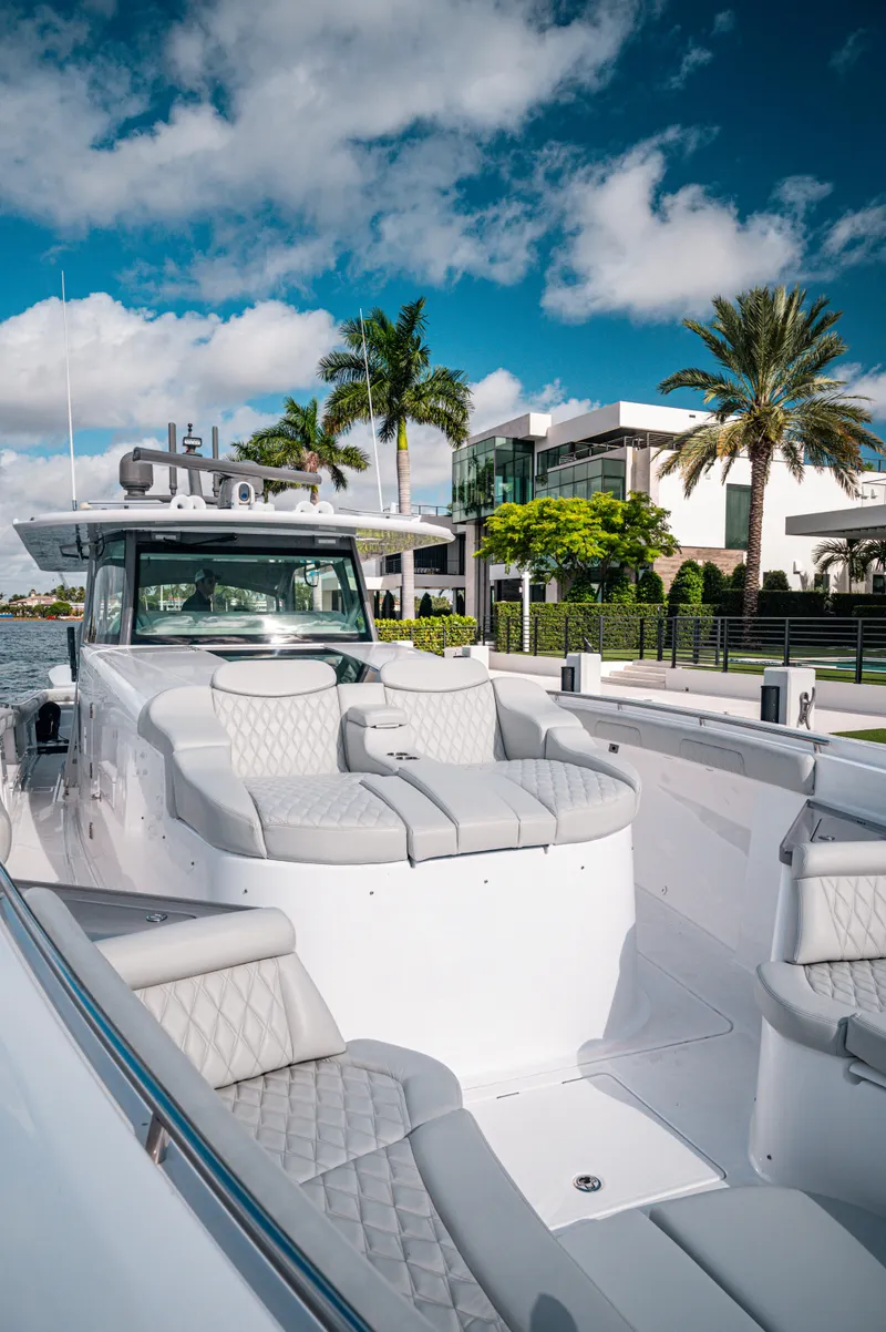 Slide: The Image of 2023 HCB 65 Estrella luxury yacht with modern seating and palm trees in the background. - 15