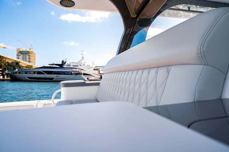 Slide: The Image of Luxury seating on the 2023 HCB 65 Estrella yacht, docked with other boats in the background. - 17