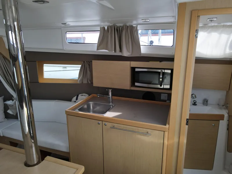 Slide: The Image of Interior of 2016 Beneteau Oceanis 35.1 sailboat with kitchenette and seating area. - 14