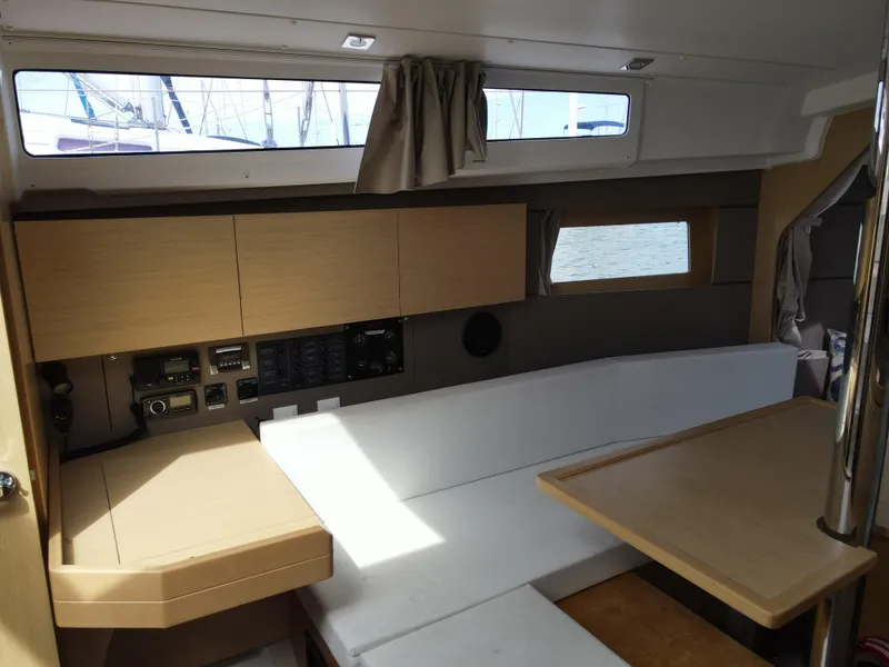 Slide: The Image of Interior of 2016 Beneteau Oceanis 35.1 sailboat with modern wood cabinetry and white seating. - 19