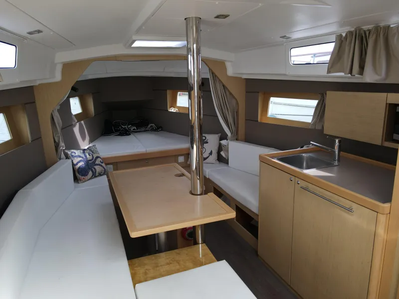 Slide: The Image of Interior of 2016 Beneteau Oceanis 35.1 sailboat with modern kitchen and cozy seating area. - 8