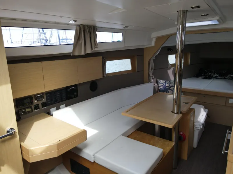 Slide: The Image of 2016 Beneteau Oceanis 35.1 interior with white seating, wooden table, and modern design. - 9