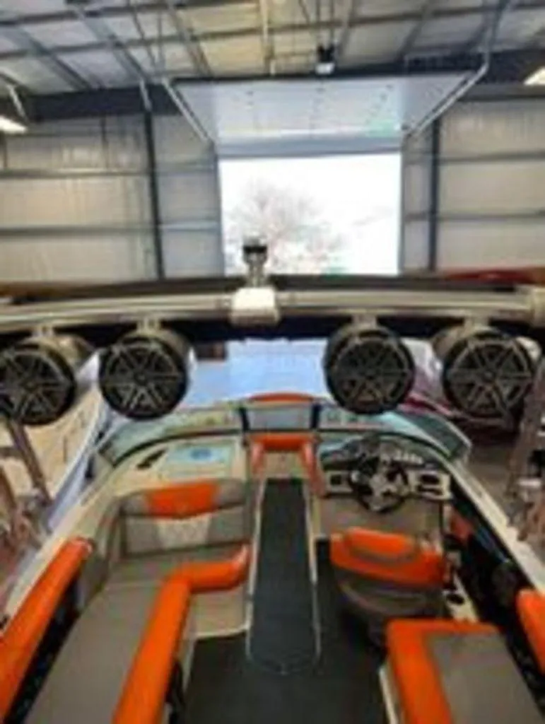 Slide: The Image of 2014 MasterCraft X30 boat interior with orange and gray seating in a garage. - 5