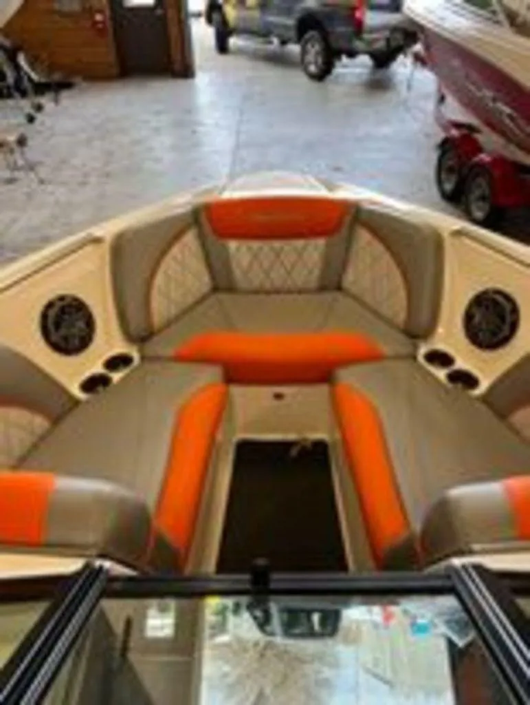 Slide: The Image of 2014 MasterCraft X30 boat interior with orange and gray seating in a garage. - 6