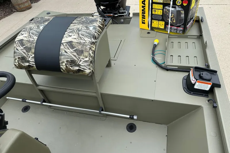 Slide: The Image of 2024 Tracker Grizzly 2072 CC Sportsman boat interior with camo seat and equipment. - 9