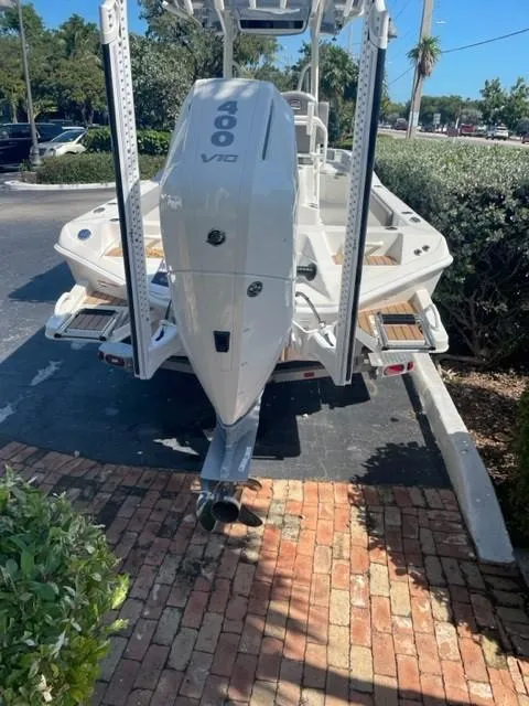Slide: The Image of 2024 Ranger 2660 Bay boat with powerful outboard motor, parked on a brick driveway. - 3