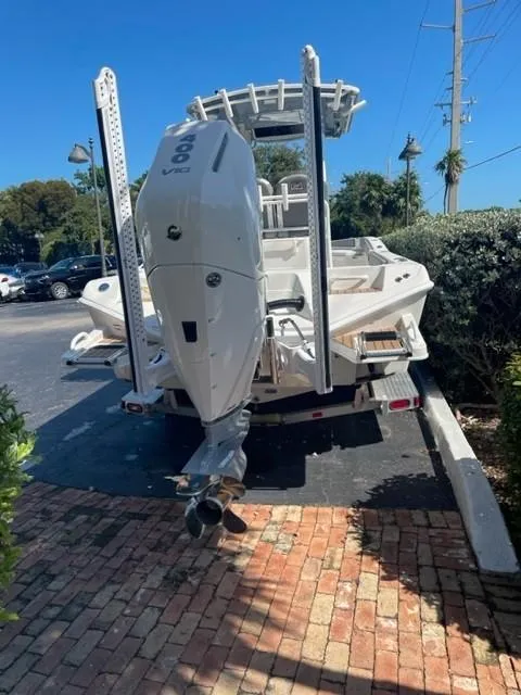 Slide: The Image of 2024 Ranger 2660 Bay boat with powerful outboard motor, parked on a brick driveway. - 4