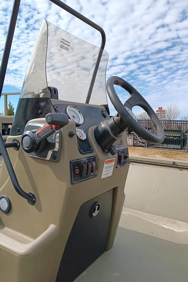Slide: The Image of 2024 Tracker Grizzly 2072 CC Sportsman boat console with steering wheel and controls. - 5