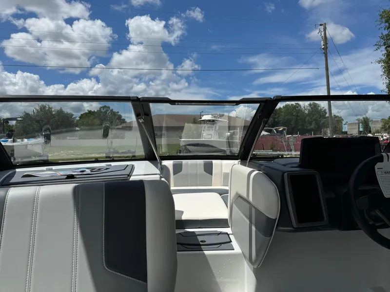 Slide: The Image of 2024 Malibu LX-R boat interior with modern dashboard and seating under a clear blue sky. - 11
