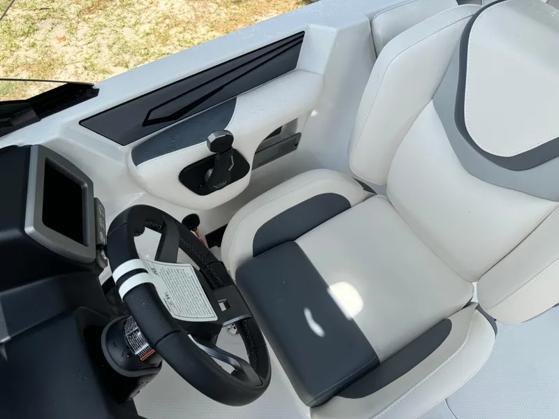Slide: The Image of 2024 Malibu LX-R boat cockpit with white and gray seating and steering wheel. - 14
