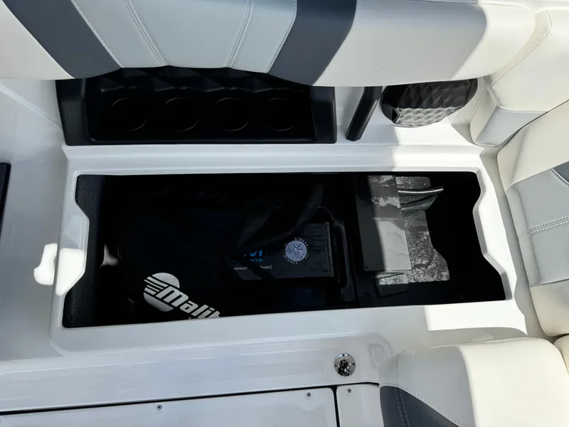 Slide: The Image of 2024 Malibu LX-R boat interior storage compartment with cup holders and seating. - 22